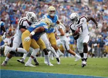  ?? Associated Press ?? n Texas A&M running back Keith Ford, right, rushes for a touchdown past UCLA linebacker Kenny Young, left, during the first half of an NCAA college football game Sunday in Pasadena, Calif.