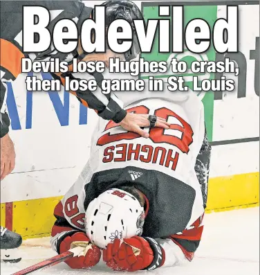  ?? USA TODAY Sports ?? JACKED UP: Devils center Jack Hughes is checked by referee Dan O’Rourke after slamming into the boards during the first period of his team’s 4-1 loss to the Blues at Enterprise Center.