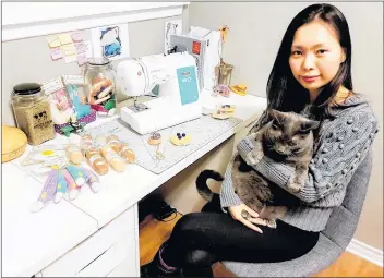  ?? SUBMITTED ?? Jenna Park holds her cat, the Grey Gatsby, at her desk, where she creates her handmade cat toys.