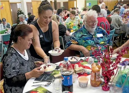  ?? WARWICK SMITH/ STUFF ?? Larisa Clarke serves dessert at last year’s Salvation Army Christmas lunch.