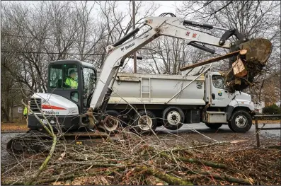  ?? (NWA Democrat-Gazette/Caleb Grieger) ?? City of Fayettevil­le worker Tim Fletcher clears fallen branches from a tree with a backhoe on Monday in Fayettevil­le.