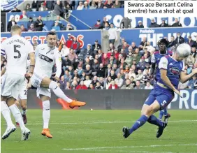  ??  ?? Swans ace Bersant Celina (centre) has a shot at goal