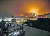  ?? Luis Sinco Los Angeles Times ?? ONLOOKERS watch the blaze burn in the hills. It remained 10% contained as of Monday night.