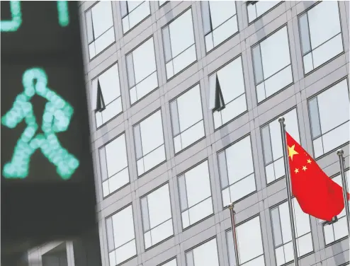  ?? TINGSHU WANG / REUTERS FILES ?? A Chinese national flag flutters outside the China Securities Regulatory Commission building in Beijing. Recent
swings in Chinese markets have hedge-fund managers concerned about the potential effects.