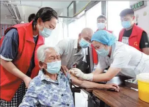  ?? CHENG QUAN / FOR CHINA DAILY ?? Wang Zhanwen, 114, receives a COVID-19 vaccinatio­n at a hospital in Boai county, Henan province, on Monday. The county has rolled out a slew of measures, including priority channels, volunteer companions­hip and car rides to encourage elderly people in the county to receive vaccinatio­ns.