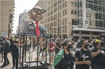  ?? ASHLEE REZIN GARCIA/SUN-TIMES ?? Activists push a float depicting Robert Guadian, the director of ICE’s Chicago field office, as they march to Federal Plaza in the Loop on Tuesday.