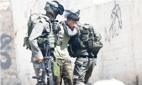  ??  ?? Israeli border police arrest a Palestinia­n during clashes in the West Bank village of Deir Abu Mash'al near Ramallah, on Saturday. (AP)