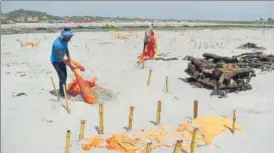  ?? HT PHOTO ?? Workers removing shrouds covering graves at Shringverp­ur Ghat on Monday.