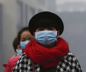  ?? REUTERS ?? WOMENweari­ng masksmake their way amid the heavy haze in Beijing. China has sent investigat­ors to parts of the country worst hit by air pollution as part of efforts to stop the heavy smog.