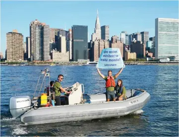  ?? — AFP photo ?? Greenpeace activists hold up a banner near the United Nations to draw attention the global ocean sanctuarie­s campaign in the East River in New York.