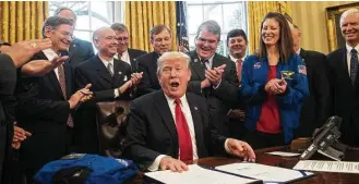  ?? Nicholas Kamm / AFP / Getty Images ?? President Donald Trump is cheered Tuesday after signing a policy bill that reaffirms the nation’s commitment to NASA. Many Texas lawmakers who pushed for the bill were at the Oval Office event.