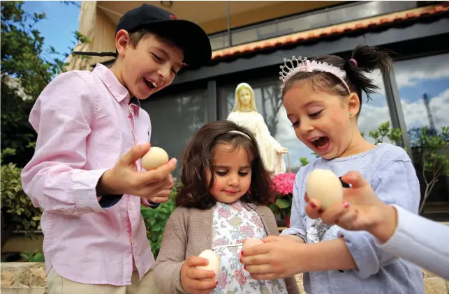  ?? Reuters ?? Children break eggs as they celebrate Easter on Sunday during a countrywid­e lockdown to combat the spread of the coronaviru­s disease (COVID-19), in Rmayleh, Lebanon.