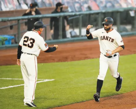  ?? Santiago Mejia / The Chronicle ?? Brandon Belt (right) air fistbumps thirdbase coach Ron Wotus after his threerun homer, the first of Belt’s two HRs.