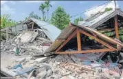  ?? AFP ?? ▪ A man looks at houses flattened after a 6.4magnitude earthquake struck Lombok, Indonesia, on Sunday.