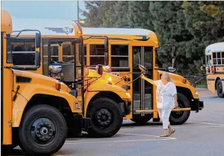  ?? BOB ANDRES / BANDRES@AJC.COM ?? A Cobb County bus driver inspects her bus recently before heading out on her morning route. Cobb officials said 42 vacancies existed as of Tuesday. School districts have struggled for several years to fill all driver positions as the unemployme­nt rate...