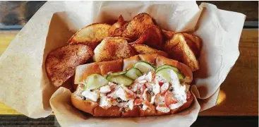  ?? Karen Warren photos / Houston Chronicle ?? South Bank Seafood Bar’s lobster roll is served on a toasted garlic roll with house-made pickles.