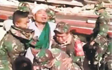  ?? Ivan Fadillah / Indonesia military ?? TV footage shows soldiers carrying a man rescued from a mosque destroyed in Sunday’s earthquake.
