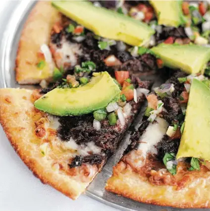  ?? Paul Stephen / Staff ?? With refried beans, cheese, avocado, pico de gallo and lots of barbacoa, the San Anto pizza at Deco Pizzeria will cure what ails.