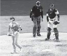  ?? ROB CARR GETTY IMAGES ?? The Dodgers’ Will Smith (left) watches his three-run home run against Atlanta to give L.A. the lead for good during the sixth inning in Game 5 of the NLCS.