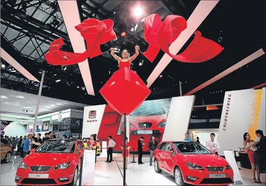  ?? FENG LI / GYI ?? Una bailarina en una ‘rosa’ el día de Sant Jordi en el stand de Seat en la Feria Internacio­nal del Automóvil en Pekín