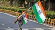  ?? — AFP ?? A boy looks for customers to sell national flags on the eve of 75th Independen­ce Day at a traffic junction in New Delhi on Saturday.