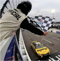  ?? (Mike Mulholland/Getty Images) ?? Christophe­r Bell, driver of the No. 20 DeWalt Toyota, takes the checkered flag to win the Cup Series Xfinity 500 at Martinsvil­le Speedway Sunday.