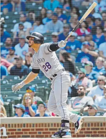  ?? Jonathan Daniel, Getty Images ?? Rockies third baseman Nolan Arenado in the first inning hits the first of his two home runs in Wednesday afternoon’s game against the Cubs at Wrigley Field in Chicago.