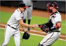  ?? CURTIS COMPTON / CCOMPTON@AJC.COM ?? Braves closer Mark Melancon celebrates with Tyler Flowers after a 2-1 win against the Rays on Thursday. Flowers made his first start since missing time with an illness.