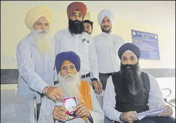  ?? SS CHOPRA/HT ?? Balbir Singh showing his son Harjit Singh’s photo in Mohali on Saturday.