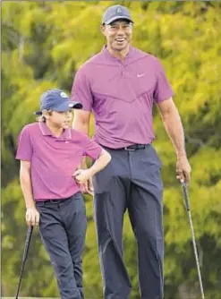  ?? AP ?? Tiger Woods and his son Charlie share a laugh while waiting to putt on 16th green during the first round of the PNC Championsh­ip.