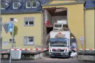  ?? (AP/dpa/Harald Tittel) ?? A rental truck is stuck Wednesday in a house passageway in Trier, Germany. Parts of the apartment building above it collapsed, but no one was injured.
