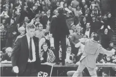  ?? JOURNAL SENTINEL FILES ?? Glenn Hughes (center, crowd), father of Wisconsin’s Kim and Kerry Hughes, expresses his feelings toward Al McGuire and Hank Raymonds in 1974.