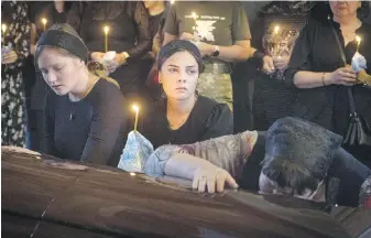  ?? EFREM LUKATSKY, AP ?? Relatives attend the funeral at St Michael Cathedral’s in Kyiv of a Ukrainian soldier who was killed by Russian troops in battle.