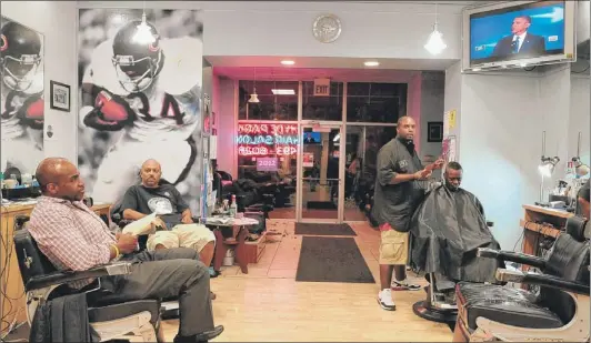  ?? | TOM CRUZE~SUN-TIMES ?? Barbers and customers at the Hyde Park Hair Salon watch President Barack Obama’s speech Thursday night.