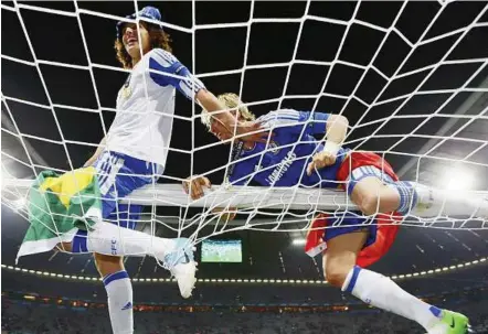  ?? — Reuters ?? Top of the world: David Luiz (left) and Fernando Torres celebrate Chelsea’s Champions League win on the crossbar at the Allianz Arena in Munich on Saturday.