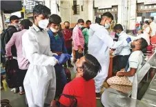  ?? PTI ?? Health workers collect swab samples from passengers for Covid-19 testing at CSMT Railway Station in Mumbai, Maharashtr­a, on Monday.