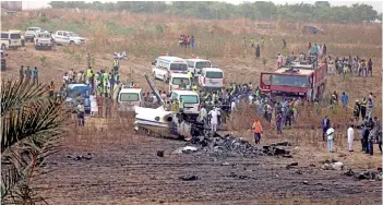  ?? — AFP photo ?? Caregivers work at the scene of an accident involving a Nigerian military aircraft which crashed killing seven occupants on board at the Airport runway near Nigeria’s capital Abuja.
