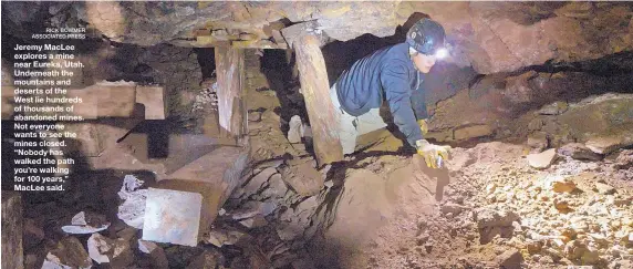  ?? RICK BOWMER ASSOCIATED PRESS ?? Jeremy MacLee explores a mine near Eureka, Utah. Underneath the mountains and deserts of the West lie hundreds of thousands of abandoned mines. Not everyone wants to see the mines closed. “Nobody has walked the path you’re walking for 100 years,” MacLee said.