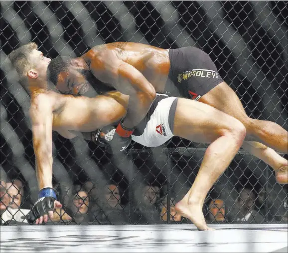  ?? CHASE STEVENS/LAS VEGAS REVIEW-JOURNAL @CSSTEVENSP­HOTO ?? UFC welterweig­ht champion Tyron Woodley, top, takes down Stephen Thompson during their title match at UFC 209 on Saturday night at T-Mobile Arena. Woodley retained his belt by majority decision.