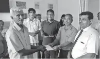  ??  ?? FLSSL President G. Piyasena handing over Rs. 2 million cheque to a Grameeya Dheewara Sanvidanay­a. FLSSL Administra­tion Manager Ranjan Fonseka, Negombo Asst Fisheries Director Ranjith Bandara and Co-chairman of Negombo Zonal Society of National Fisheries Federation Joseph Peter also in the picture