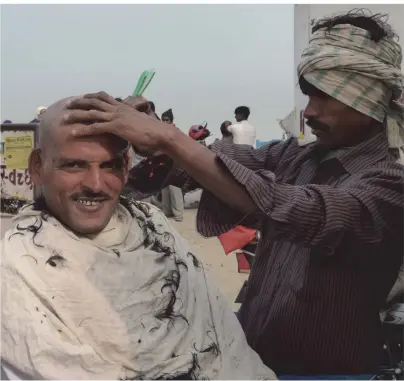  ??  ?? In diesem kleinen indischen Dorf am Ganges schneidet der Friseur seinen Kunden direkt auf der Straße unter freiem Himmel die Haare.