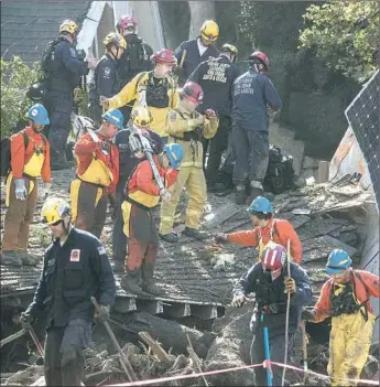  ?? Brian van der Brug Los Angeles Times ?? ORANGE COUNTY Urban Search and Rescue members wait for heavy equipment to peel back layers of debris amid the rubble of a home destroyed by Tuesday’s mudslides in Montecito, Calif.