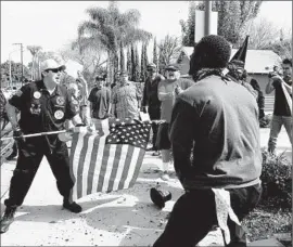  ?? Luis Sinco Los Angeles Times ?? A KLANSMAN defends himself with the point of a f lagpole. The head of the O. C. Human Relations Commission doubts the KKK will soon return to Anaheim.