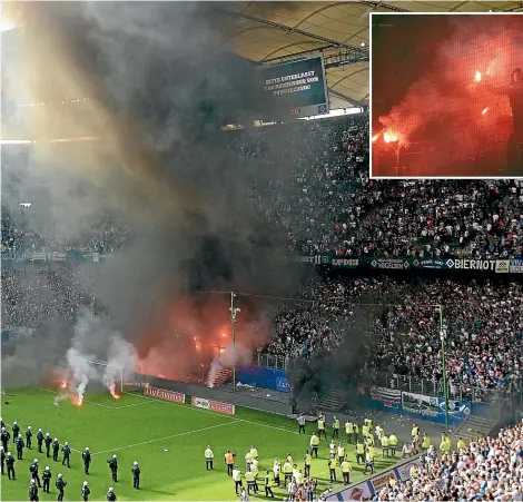  ?? DPA/GETTY IMAGES ?? Riot police storm the field as fans light flares and throw objects when Hamburg were relegated from the German Bundesliga despite beating Borussia Moenchengl­adbach in the final match of the 2017-18 season.