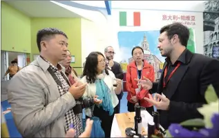  ??  ?? A business representa­tive from Italy introduces wines produced by his company to visitors at the 2015 China