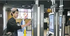  ??  ?? Brandon Alba of Milwaukee orders food at a self-service kiosk June 1 at a McDonald's restaurant in Chicago.