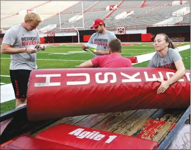  ?? AP/NATI HARNIK ?? Nebraska student manager Kelli Leachman (right) carries a goal post pad Aug. 10 as she and other managers prepare for football practice in Lincoln, Neb.