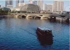  ??  ?? A boat travelling up the Singapore River.