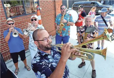  ?? PHOTOS BY FRED SQUILLANTE/COLUMBUS DISPATCH ?? Musical director Martin Williams, foreground, plays his double-bell trumpet along with the other members of the Nationwide Children’s Hospital Orchestra (NACHO) Street Band during the Avenue for All Festival on Saturday on Parsons Avenue.