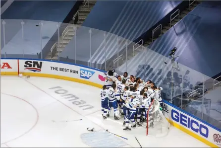  ?? The Associated Press ?? Tampa Bay Lightning players celebrate in an empty arena after defeating the Dallas Stars to win the Stanley Cup in Edmonton on Sept. 28.